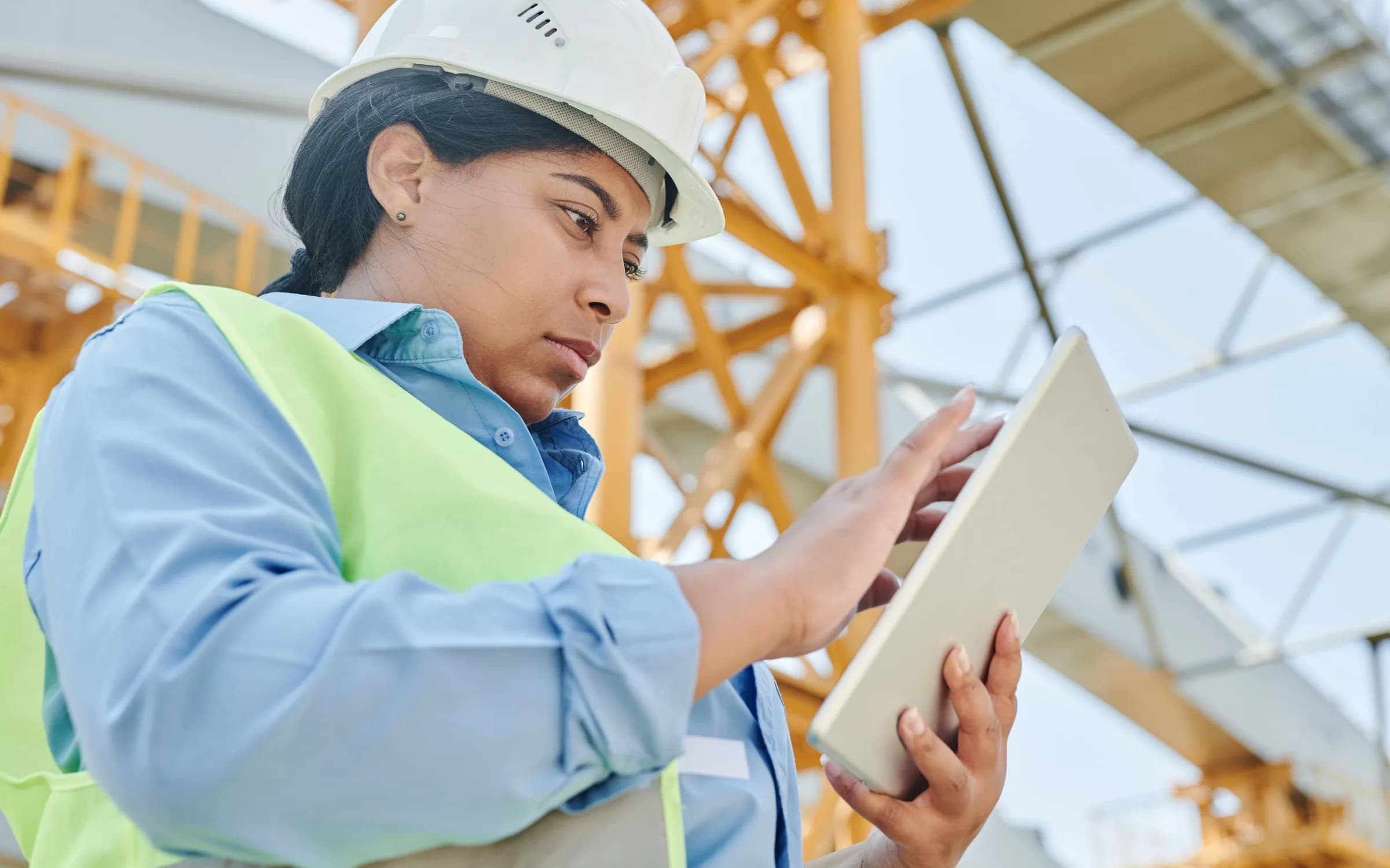 A project engineer in a safety vest checking a tablet on an active site