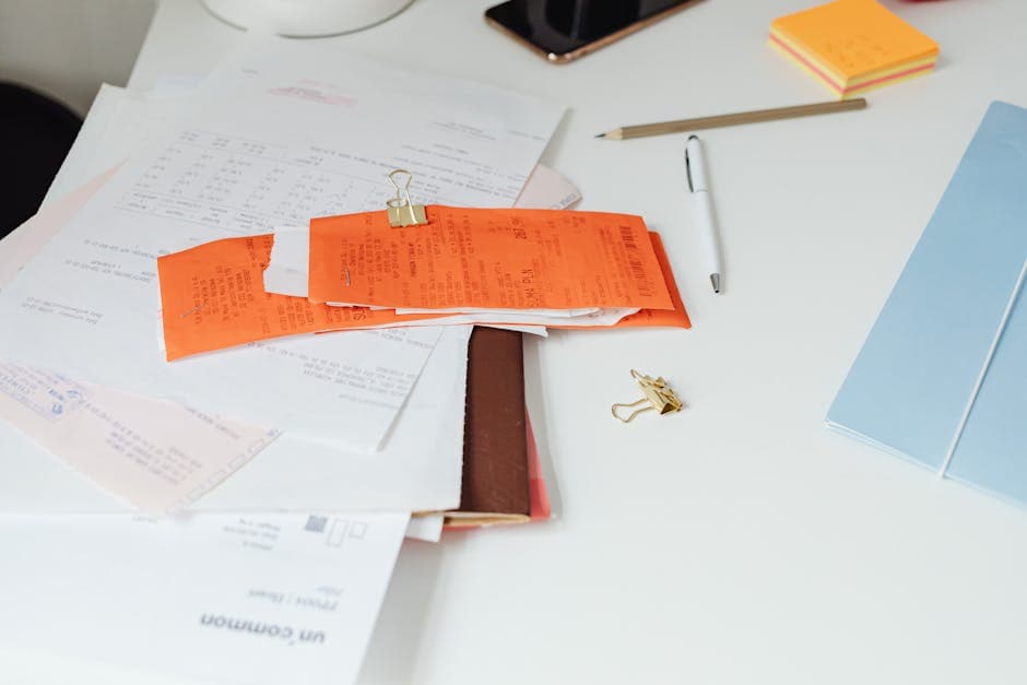 Stack of vendor invoices and accounting documents on a desk
